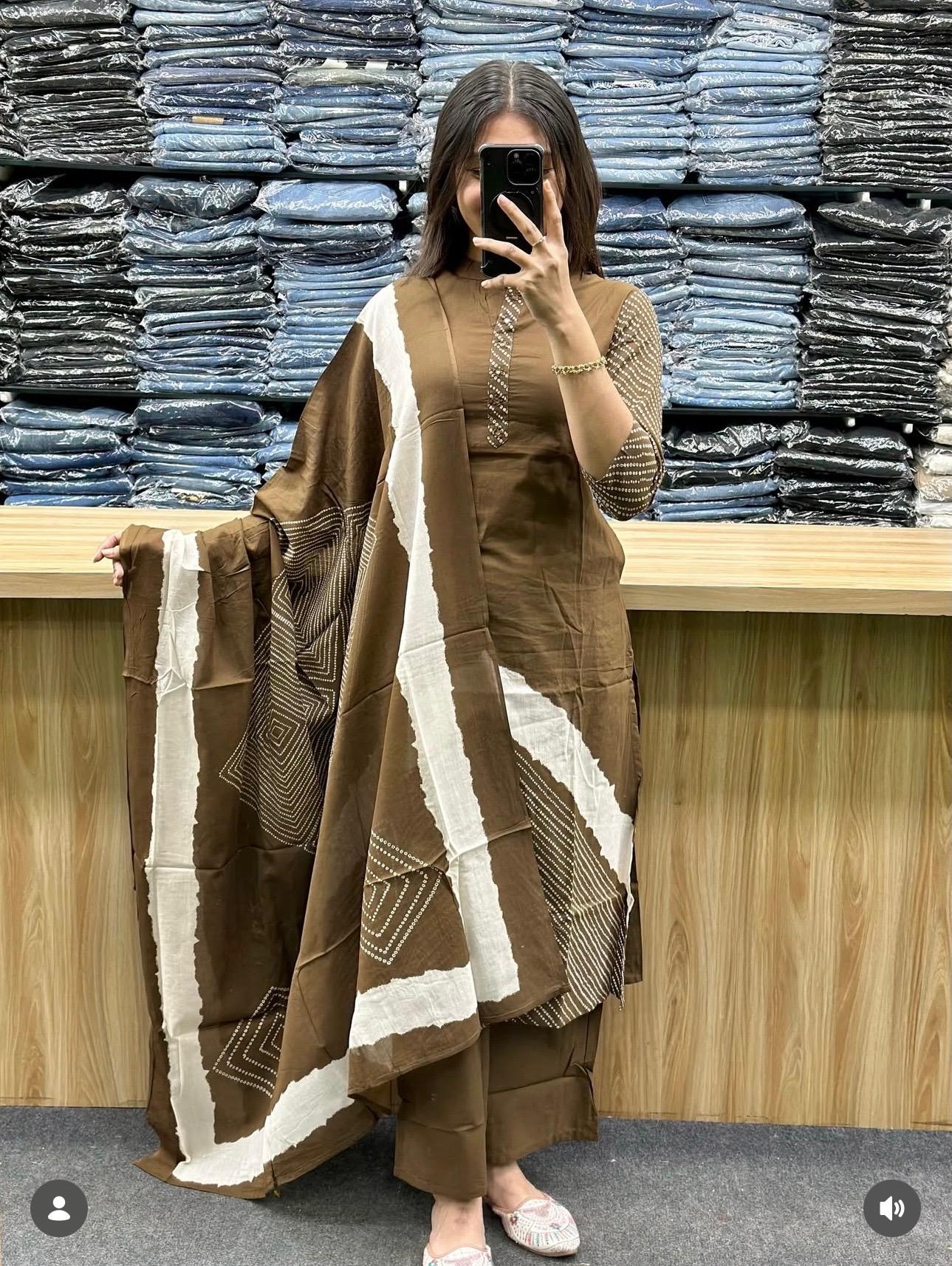 Person holding a brown and white patterned fabric in front of stacked denim jeans.