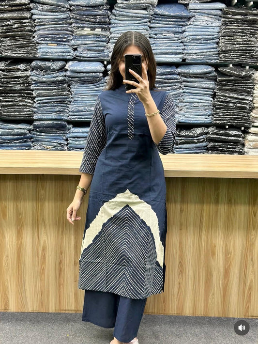 Person wearing a blue and white dress standing in front of stacks of jeans.